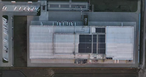 Large scale distribution center warehouse at sunset. Top down birds eye Stock Footage 261396364