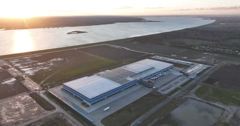 Large scale distribution center warehouse at sunset. Trucks delivering goods Stock Footage 261731717