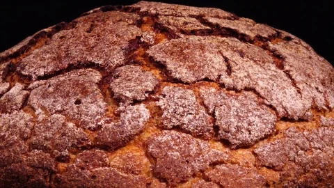 Large scale of fresh baked round bread rotating against black background. 4k Vídeo Stock 73085681