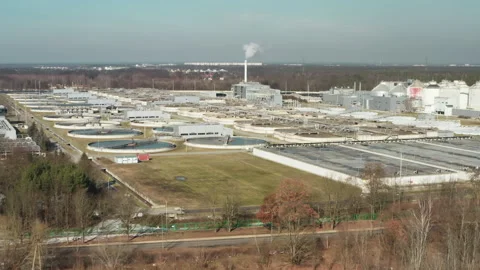Large scale sewage treatment infrastructure near urban forest area Stockbeeldmateriaal 329754093