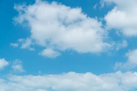 Large scattered white clouds on a blue sky above Stock Photos