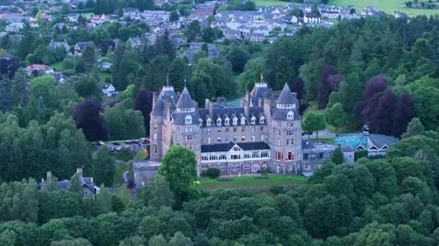 A large Scottish castle with a green hillside in the background Stock Footage 306489401