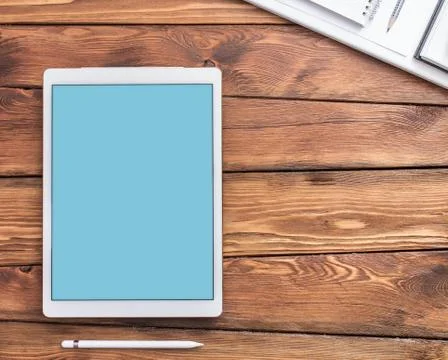 Large screen tablet device on a wooden desktop, top view. Photos