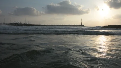 Large sea waves with splashes of foam and water on the beach with yacht port Stock Footage 93556660