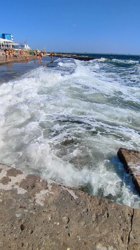 Large sea waves white foam hitting splashing concrete pier which people standing Stock Footage 279317225