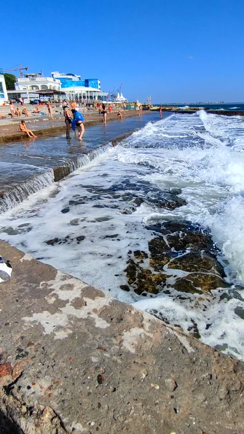 Large sea waves white foam hitting splashing concrete pier which people standing Stock Footage 287403581