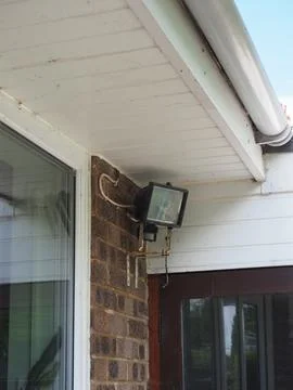 A large security floodlight with sensor on the side of a house Stock Photos