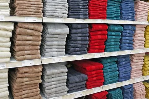 Large selection of bath towels stacked by color. Stock Photos