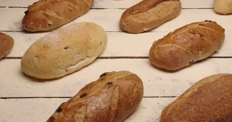 A large selection of different breads are laid out on the table. 動画素材 167120893