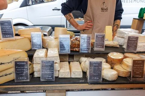 A large selection of different cheeses on the counter of a small store at the Stock Photos