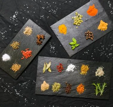 Large selection of different colorful contrast spices and seeds on slate Stock Photos