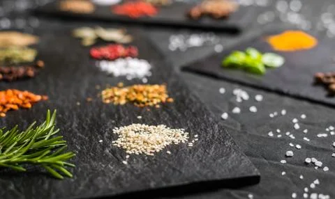 Large selection of different colorful contrast spices and seeds on slate Stock Photos