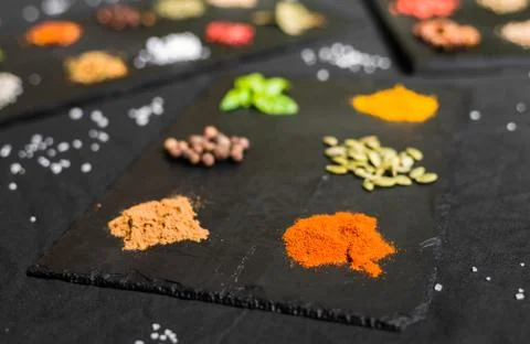 Large selection of different colorful contrast spices and seeds on slate Stock Photos