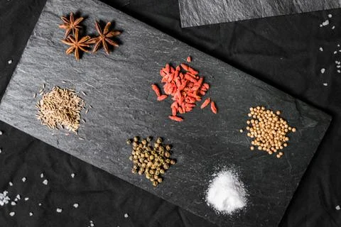 Large selection of different colorful contrast spices and seeds on slate Stock Photos