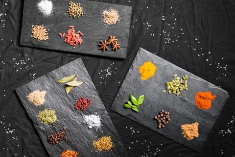 Large selection of different colorful contrast spices and seeds on slate Stock Photos