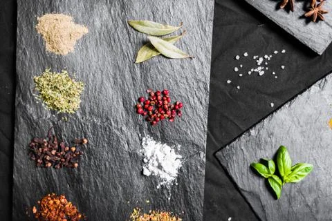 Large selection of different colorful contrast spices and seeds on slate Stock Photos