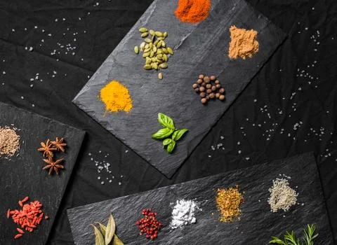 Large selection of different colorful contrast spices and seeds on slate Stock Photos