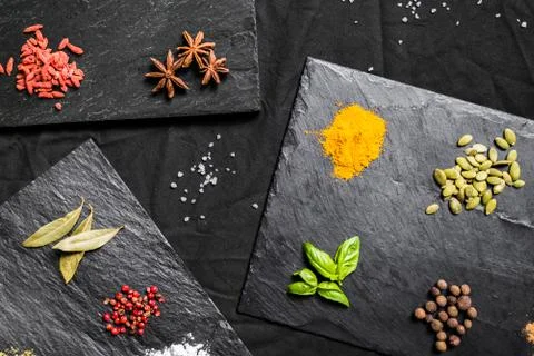 Large selection of different colorful contrast spices and seeds on slate Stock Photos