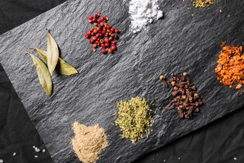 Large selection of different colorful contrast spices and seeds on slate Stock Photos