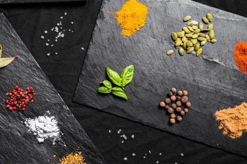 Large selection of different colorful contrast spices and seeds on slate Stock Photos