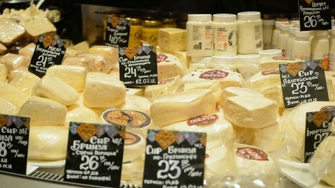 A large selection of different french and italian cheeses on display in a French Video stock 100559646