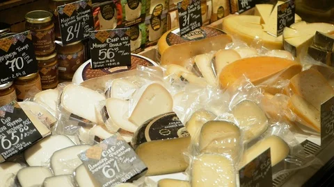 A large selection of different french and italian cheeses on display in a French Video stock 100559660