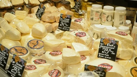 A large selection of different french and italian cheeses on display in a French Video stock 100559701
