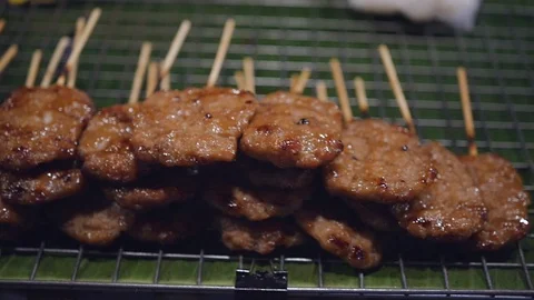 A large selection of different meats lies on the barbecue in the evening market Stock Footage 89156196