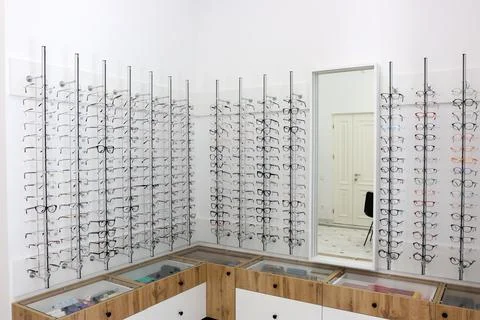 Large selection of eyeglass frames displayed on stands in a modern optical st Stock Photos