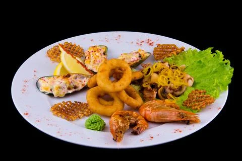 Large selection of fried seafood snacks. Stuffed mussels, breaded squid rings Stock Photos