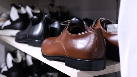 Large selection of men boots of different styles and colors on shelf in store Video stock 270483169