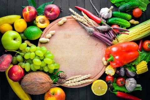 Large selection of raw vegetables and fruits on a black wooden table. Free sp Stock Photos