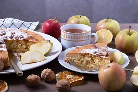 Large serving of apple pie with walnuts surrounded by ripe apples. Stock Photos