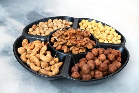 A large serving platter with five compartments in assorted shelled nuts Photos