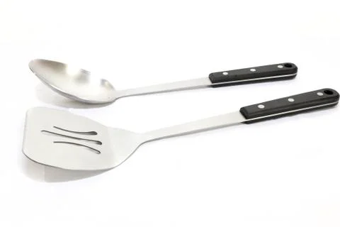 Large serving spoon and a spatula with black handles on a white bacground Stock Photos