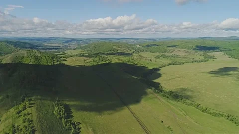 A large shadow from the cloud fell on the green meadow outside the city Stock Footage 151553639