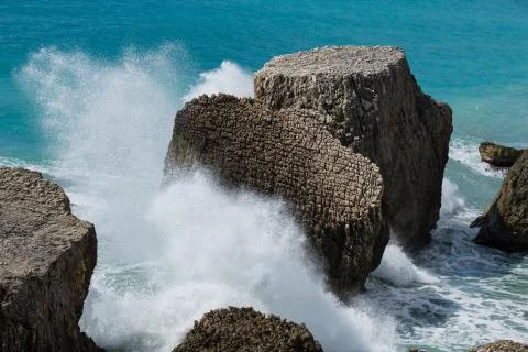 Large sharp rocks with forceful waves splashing against rocks Stock Photos