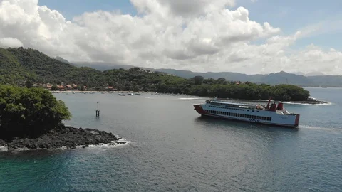 A large ship arriving from the open ocean entering balinese pier on a sunny day  Stock Footage 129554624