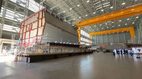 Large Ship Section Under Construction Inside a Vast Industrial Hangar with Stock Footage 329498793