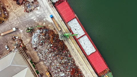 Large ship unloads scrap metal at a port while cranes move debris near the water 스톡 동영상 341570495