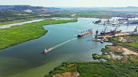 Large ships navigate a river while cranes and cargo containers are seen on the Stock Footage 341032998