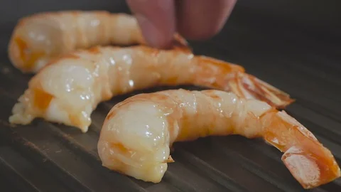 Large shrimp are grilled in a pan. Cook hand puts and turns the shrimp in the Stock Footage 101863218
