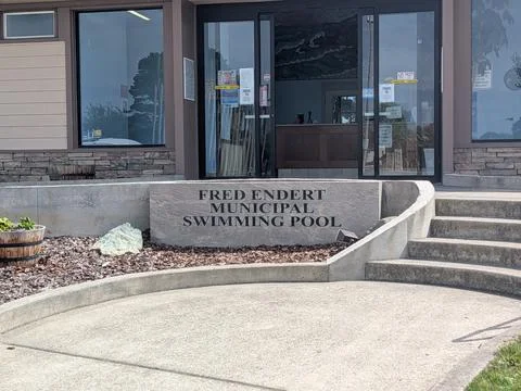 Large sign marks Fred Endert Swimming Pool with open door behind 库存照片