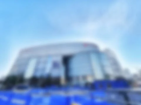 Large silver building sits under a bright blue sky, rendered with soft focus  Stock Photos