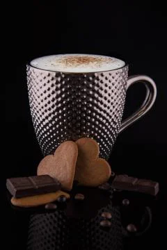 Large silver mug of coffee with reflective pimples and gingerbiscuits chocola Stock Photos