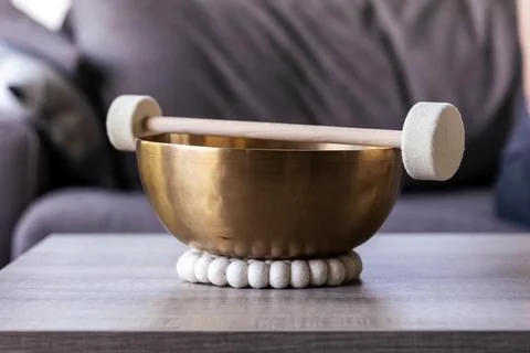 A large singing bowl, also called a himalayan bowl, with a mallet lying on .. Stock Photos
