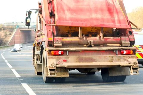 A Large Skip Lorry Carrying A Skip To Or From A Site To Fill Or Empty It Stock Photos