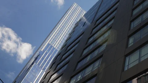 Large skyscraper reflects fast moving clouds in windows with time-lapse. Stock-Footage 124700053
