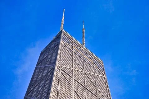 A large skyscraper rises over a cityscape with modern buildings in the fore.. Stock Photos