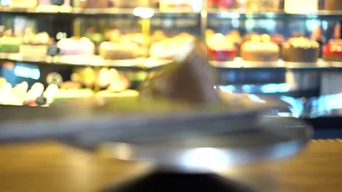 A large slice of chocolate cake and cupcakes in the display case Stock Footage 167588128